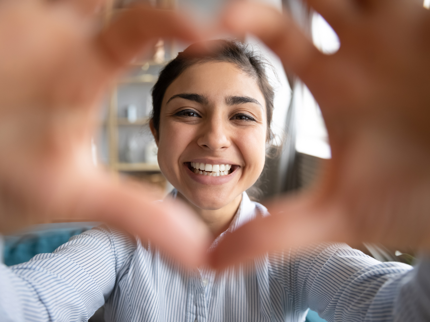 A woman making a heart gesture