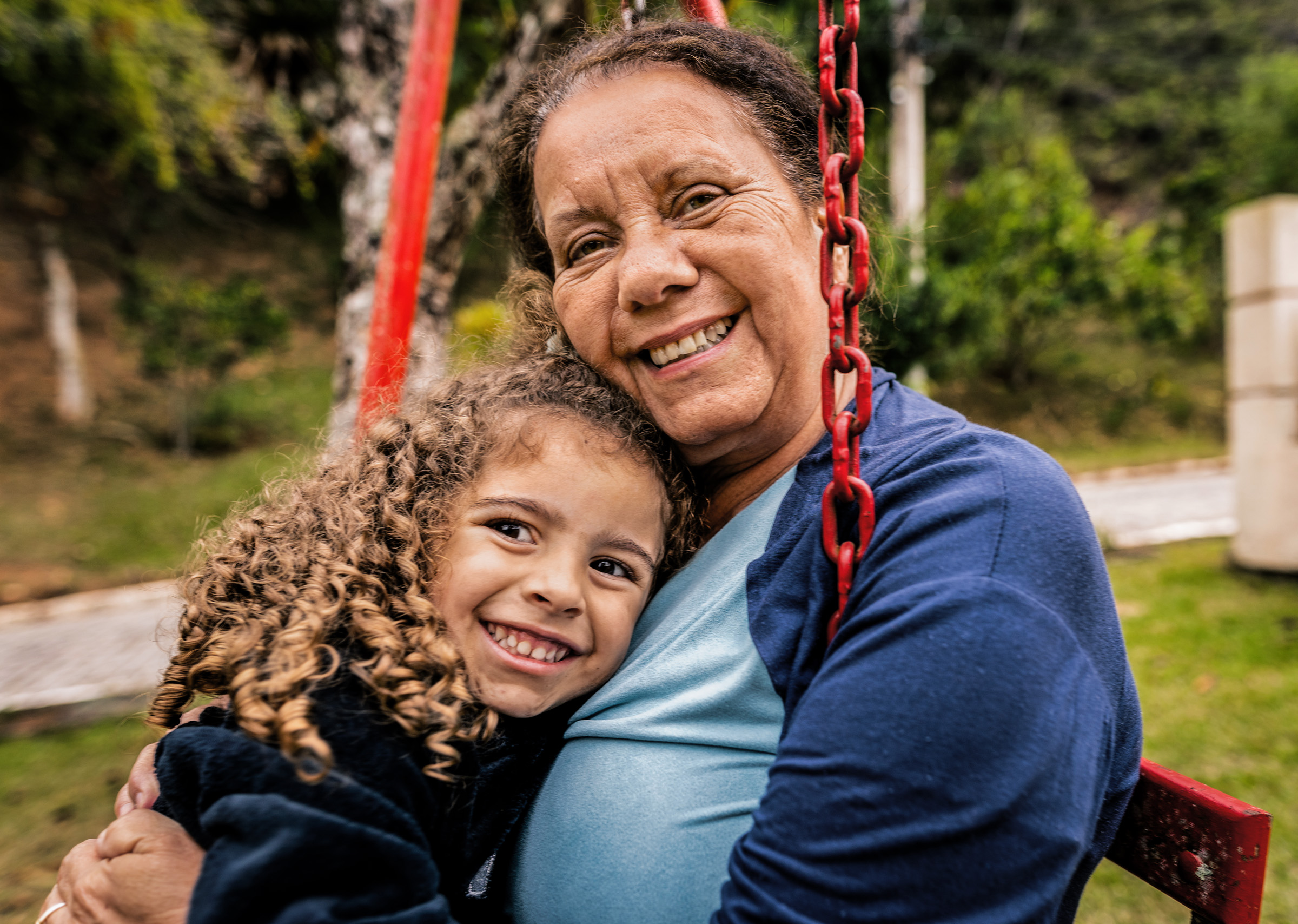 Madre e hija sonriendo en el columpio