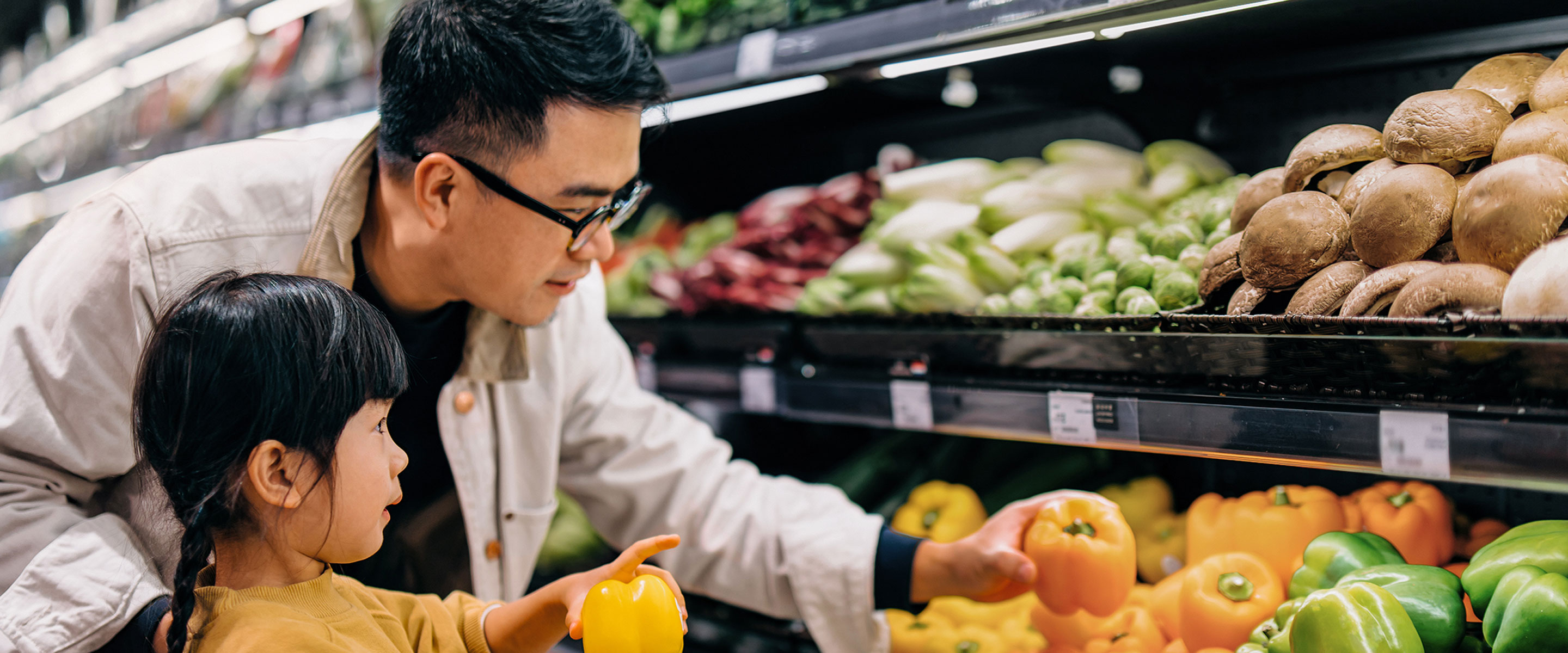 A street vendor handing vegetables to a customer