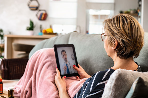 A woman using her tablet for a virtual appointment