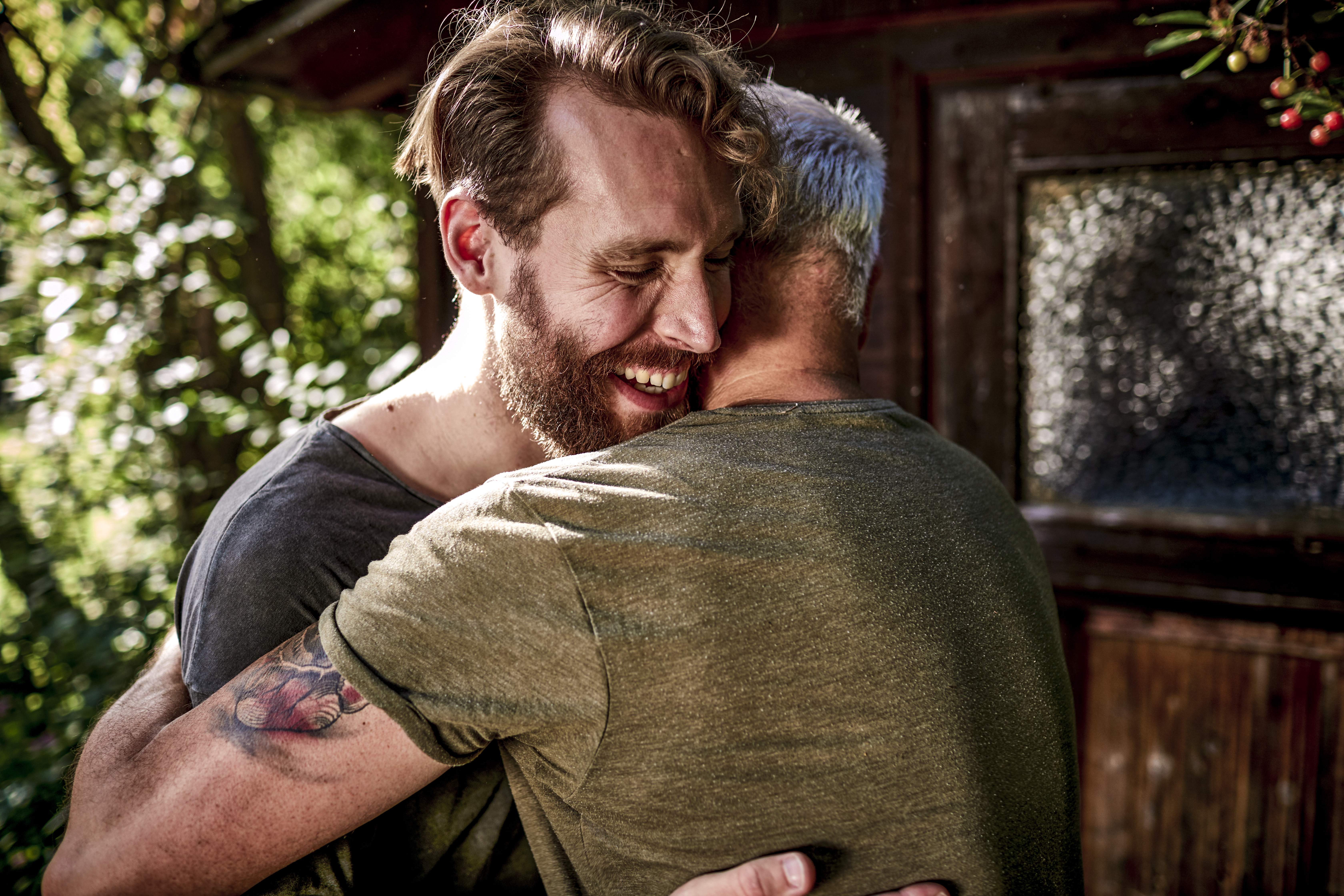 Two adult men hug each other