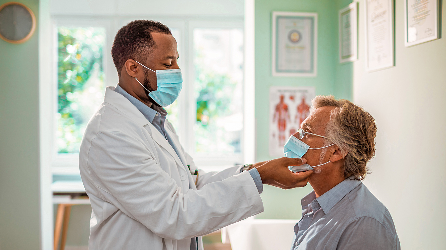 Image of a provider and his patient wearing masks in an exam room
