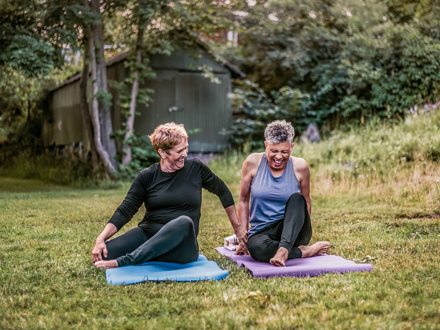 Friends doing yoga on the grass